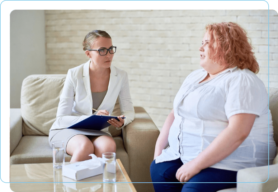 A woman sitting on the couch talking to another person.