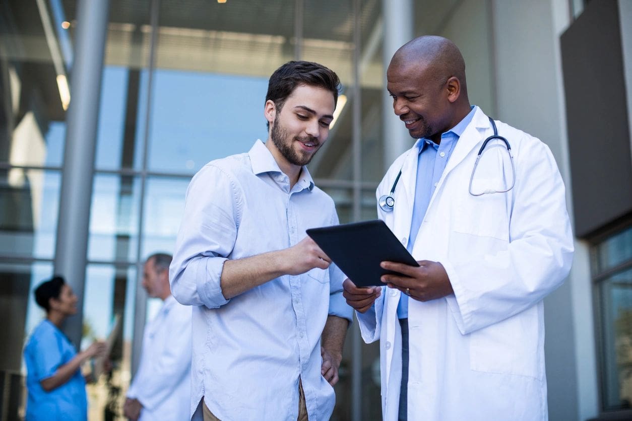 Two doctors are looking at a tablet.